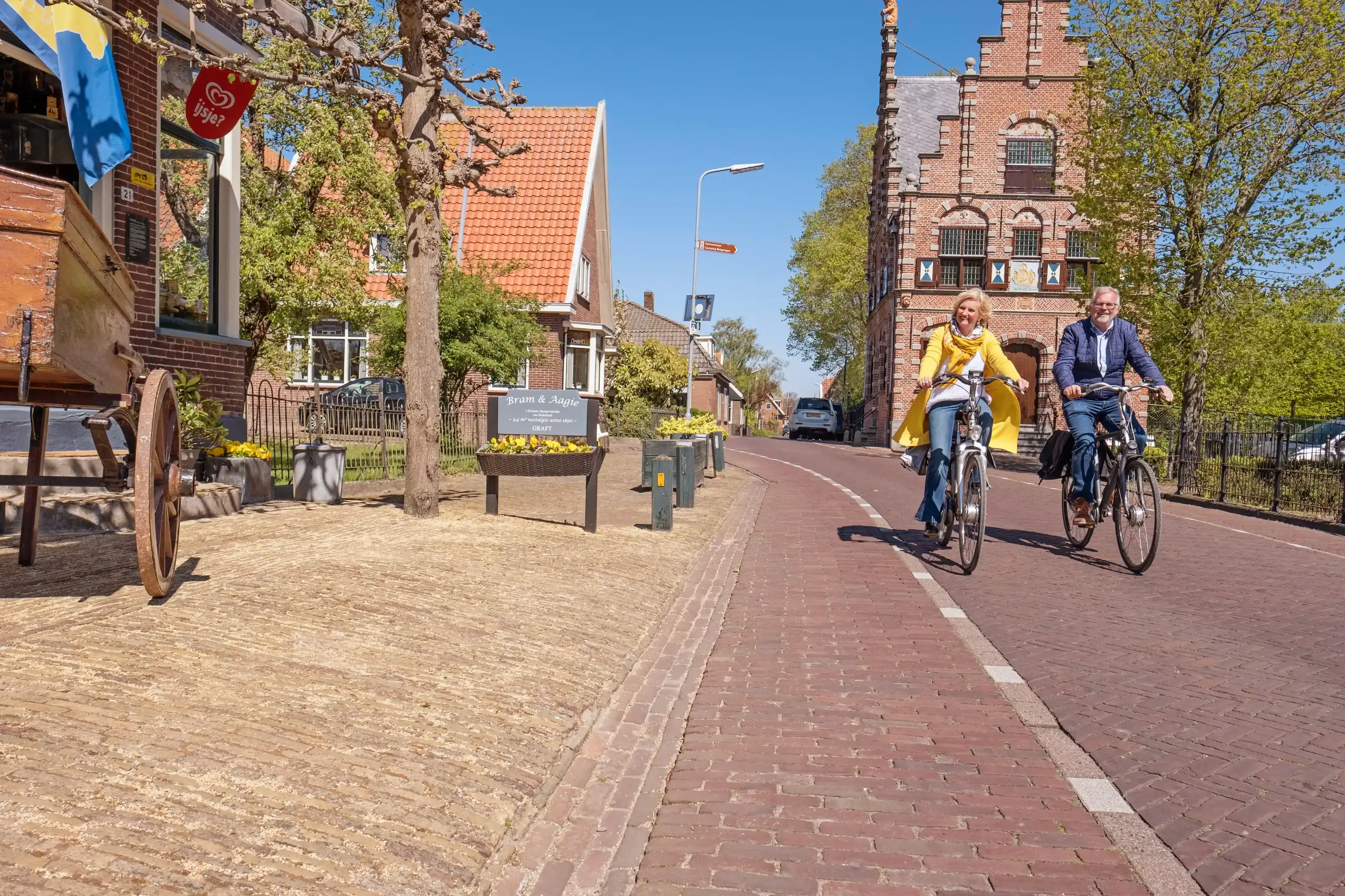man en vrouw op de fiets door het dorp De Rijp